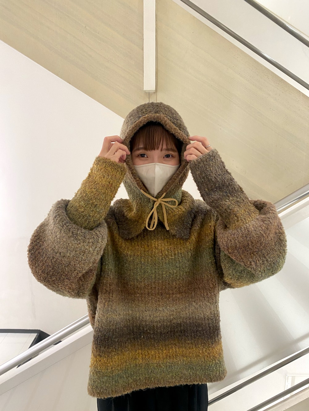 ブラウン系のニット/セーター、ブラック系のスラックスを着用したレディースの秋コーディネートの3枚目の写真