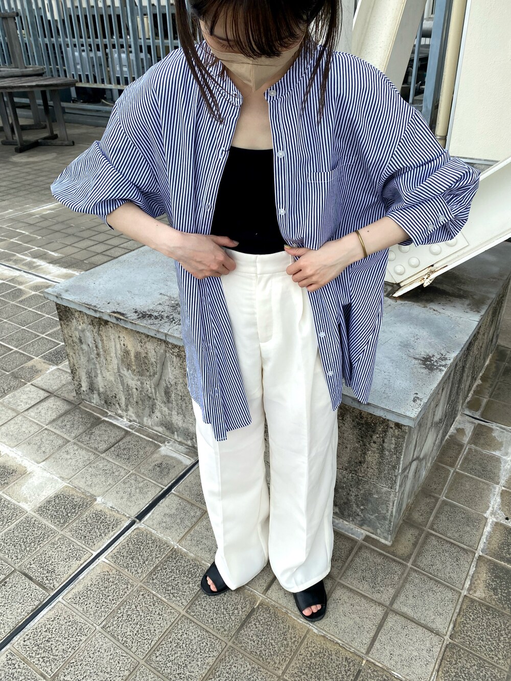 ホワイト系のスラックス、ブルー系のシャツ/ブラウス、ブラック系のタンクトップを着用したレディースの夏コーディネートの2枚目の写真