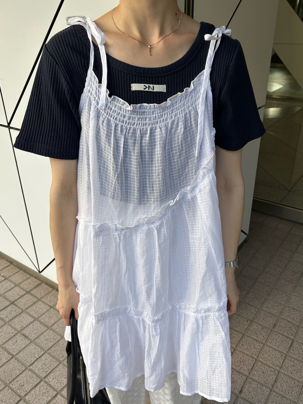 ホワイト系のチュニック、ブルー系のTシャツ/カットソー、ホワイト系のパンツを着用したレディースの夏コーディネートの2枚目の写真