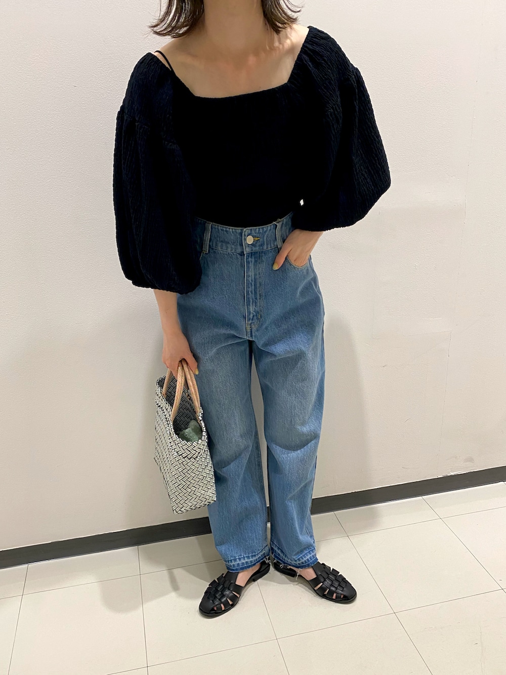 ブラック系のシャツ/ブラウス、ブルー系のデニムパンツを着用したレディースの夏コーディネートの2枚目の写真