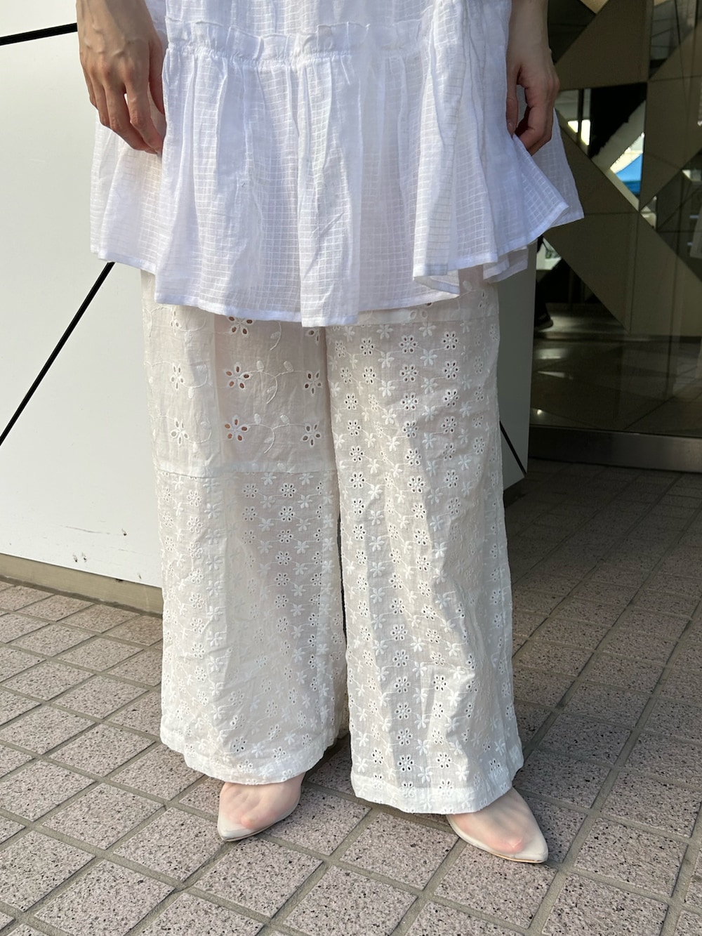 ホワイト系のチュニック、ブルー系のTシャツ/カットソー、ホワイト系のパンツを着用したレディースの夏コーディネートの3枚目の写真