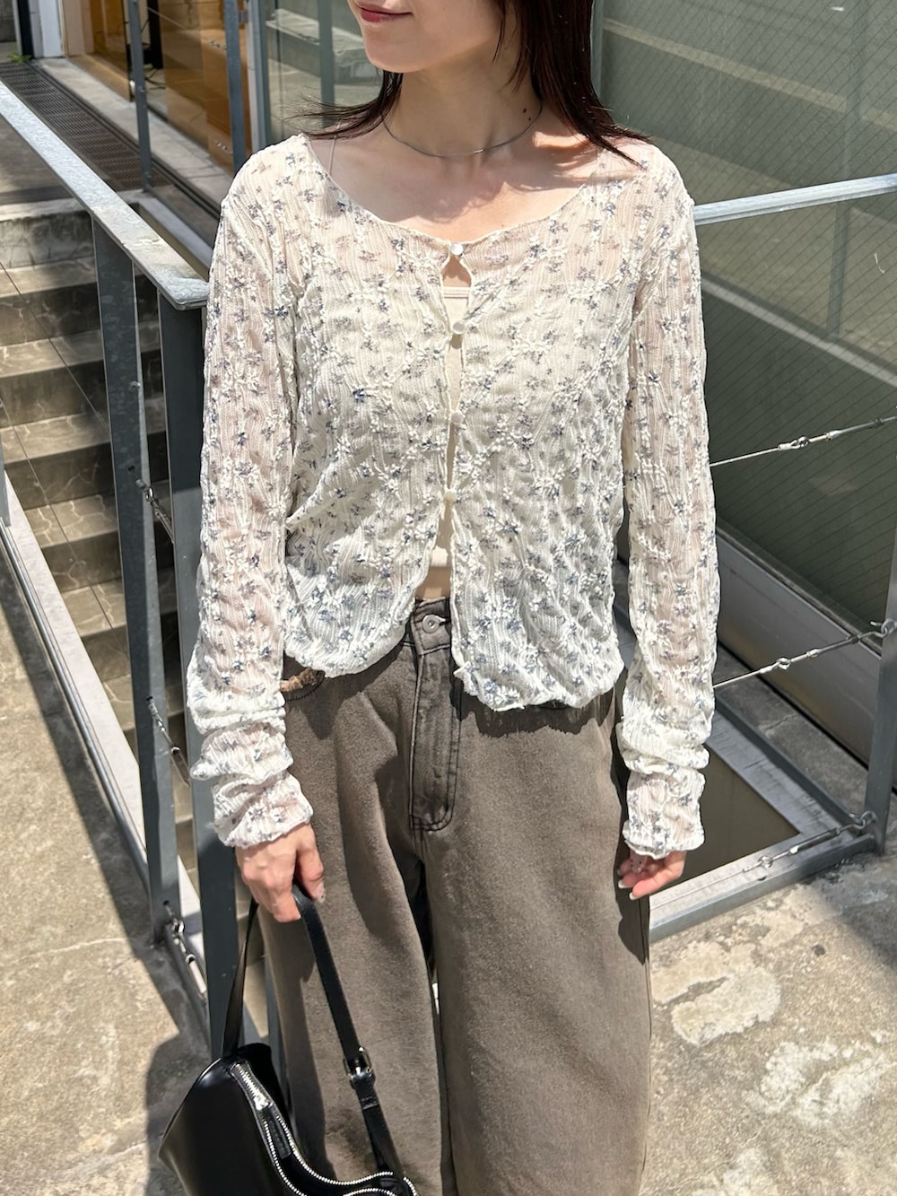 ホワイト系のカーディガン/ボレロ、グレー系のデニムパンツ、ブラック系のショルダーバッグを着用したレディースの夏コーディネートの2枚目の写真