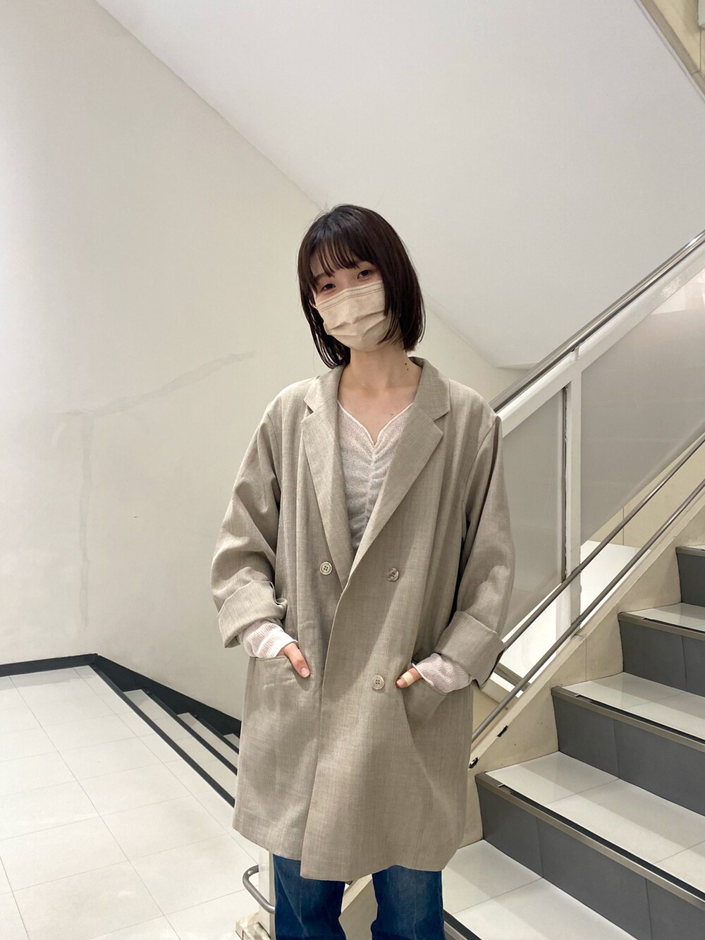 グレー系のテーラードジャケット、ホワイト系のTシャツ/カットソー、ブルー系のデニムパンツを着用したレディースの冬コーディネートの3枚目の写真