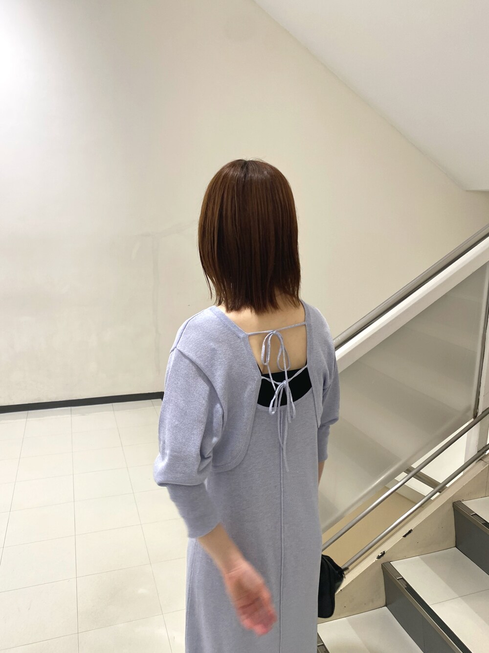 パープル系のワンピース、ブラック系のハンドバッグ、ブラック系のタンクトップを着用したレディースの春コーディネートの4枚目の写真