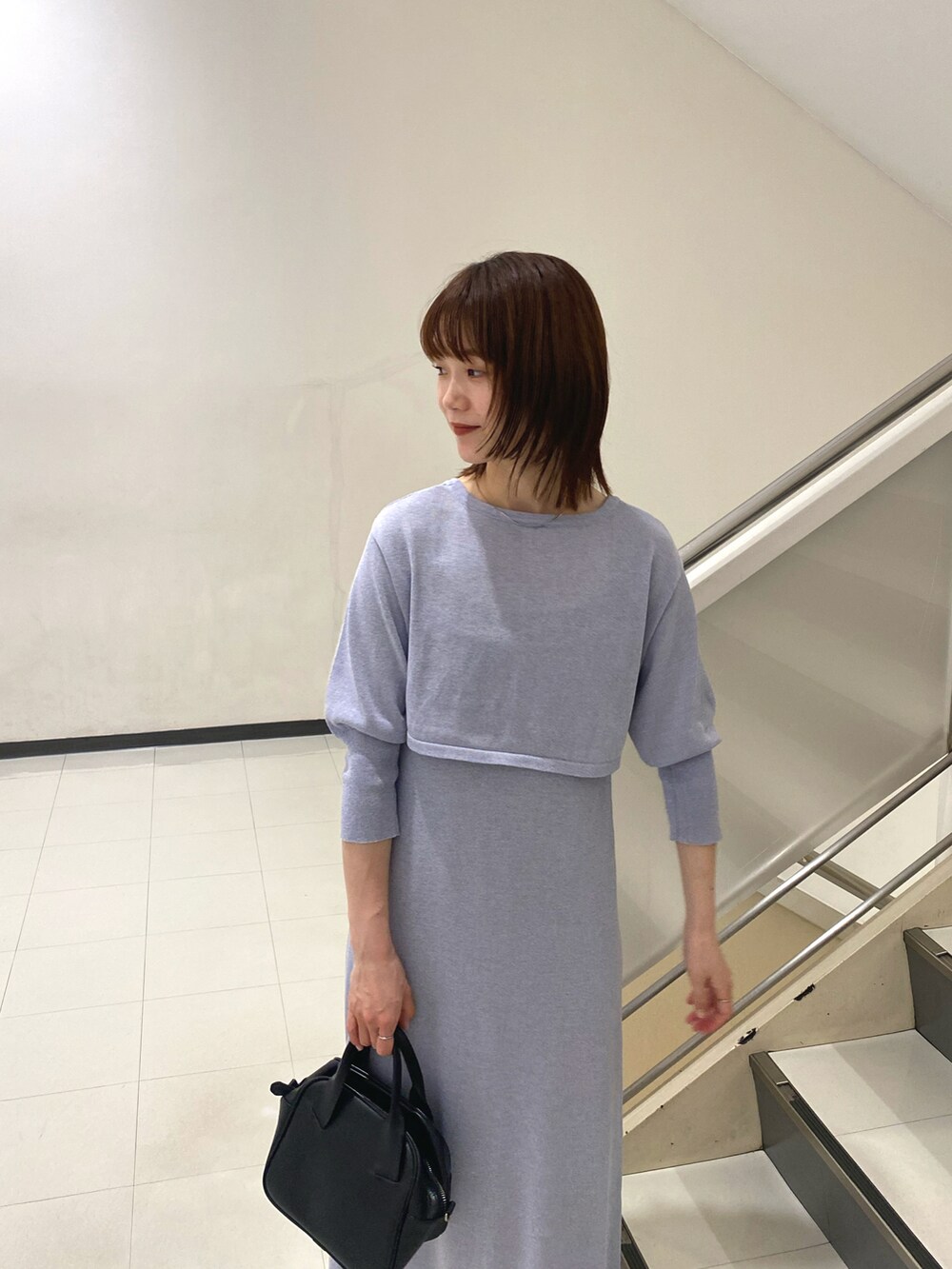 パープル系のワンピース、ブラック系のハンドバッグ、ブラック系のタンクトップを着用したレディースの春コーディネートの3枚目の写真