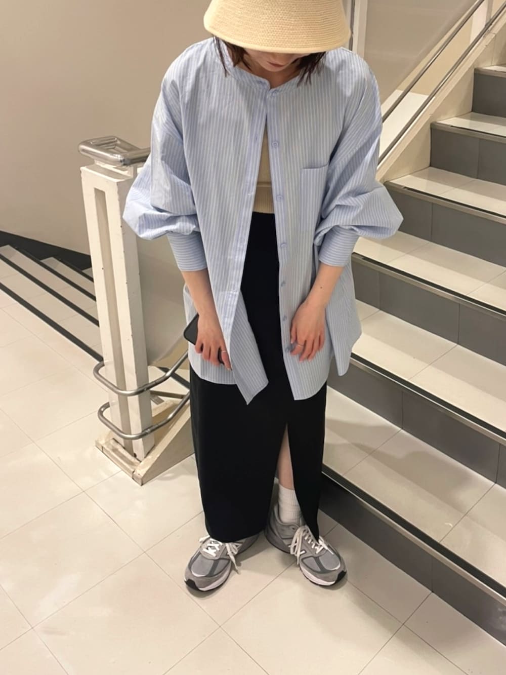 ブルー系のシャツ/ブラウス、ブラック系のスカート、ベージュ系のハットを着用したレディースの春コーディネートの3枚目の写真