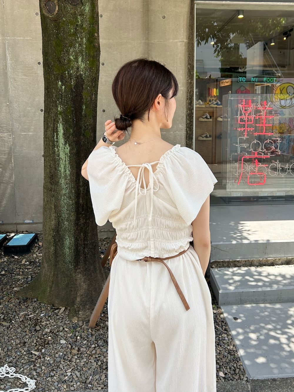 ホワイト系のサロペット/オーバーオール、ブラウン系のショルダーバッグ、ベージュ系のサンダルを着用したレディースの夏コーディネートの3枚目の写真