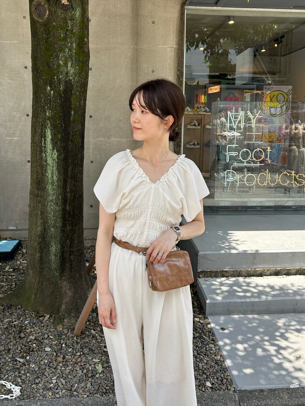 ホワイト系のサロペット/オーバーオール、ブラウン系のショルダーバッグ、ベージュ系のサンダルを着用したレディースの夏コーディネートの2枚目の写真