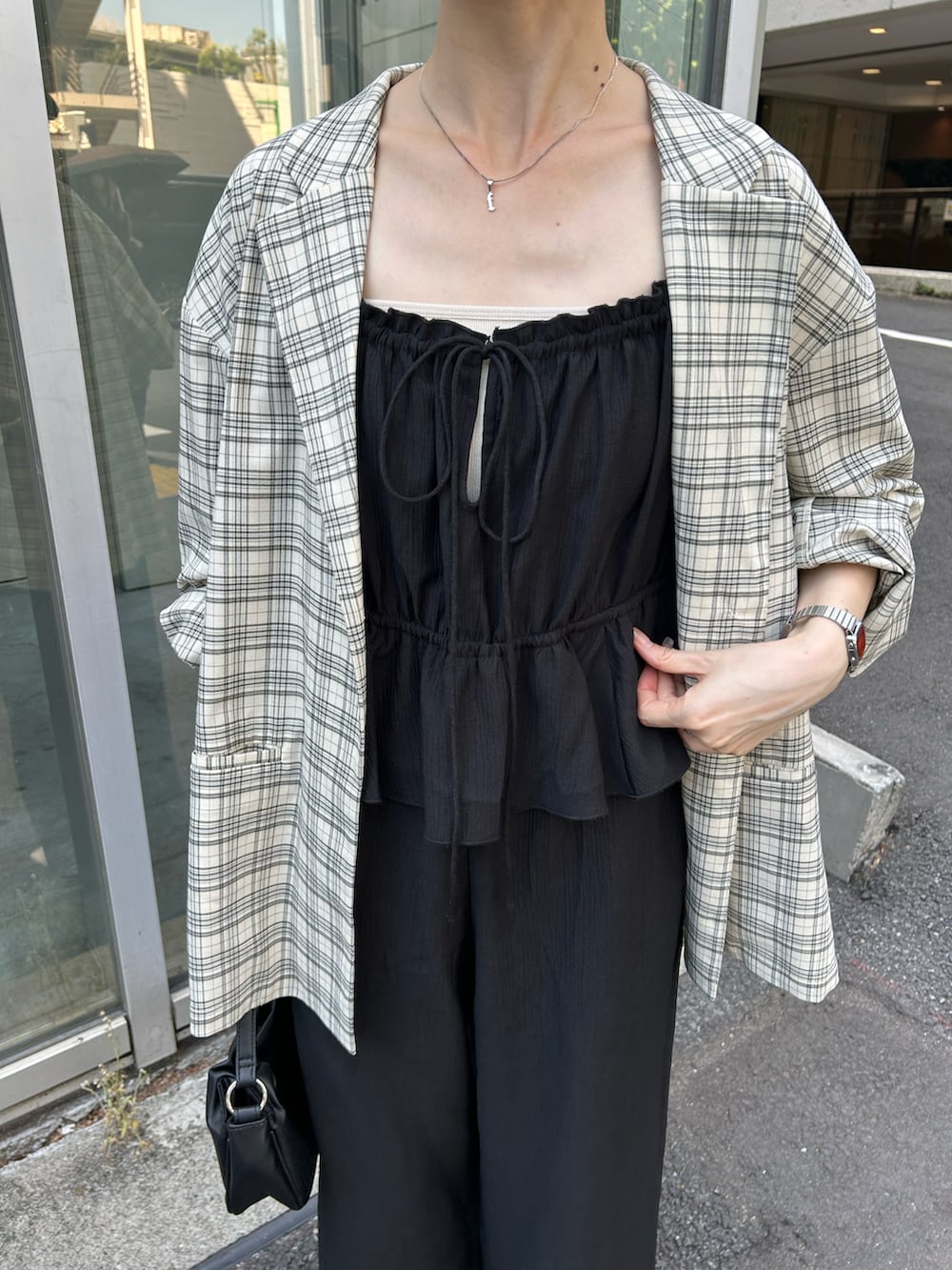 ブラック系のショルダーバッグ、ブラック系のサロペット/オーバーオール、ホワイト系のテーラードジャケットを着用したレディースの夏コーディネートの2枚目の写真