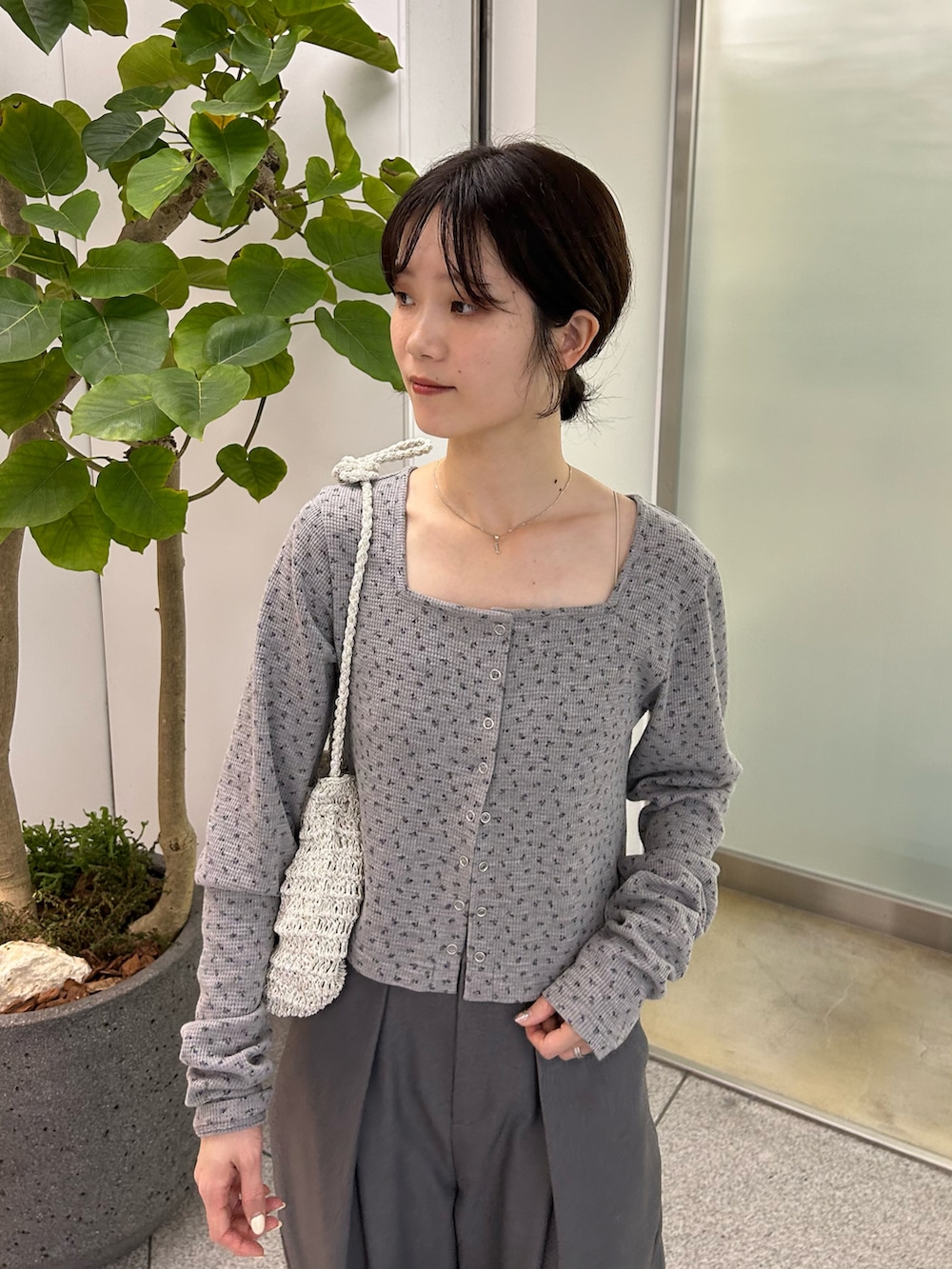 グレー系のカーディガン/ボレロ、グレー系のスラックス、ブラック系のサンダルを着用したレディースの春コーディネートの3枚目の写真