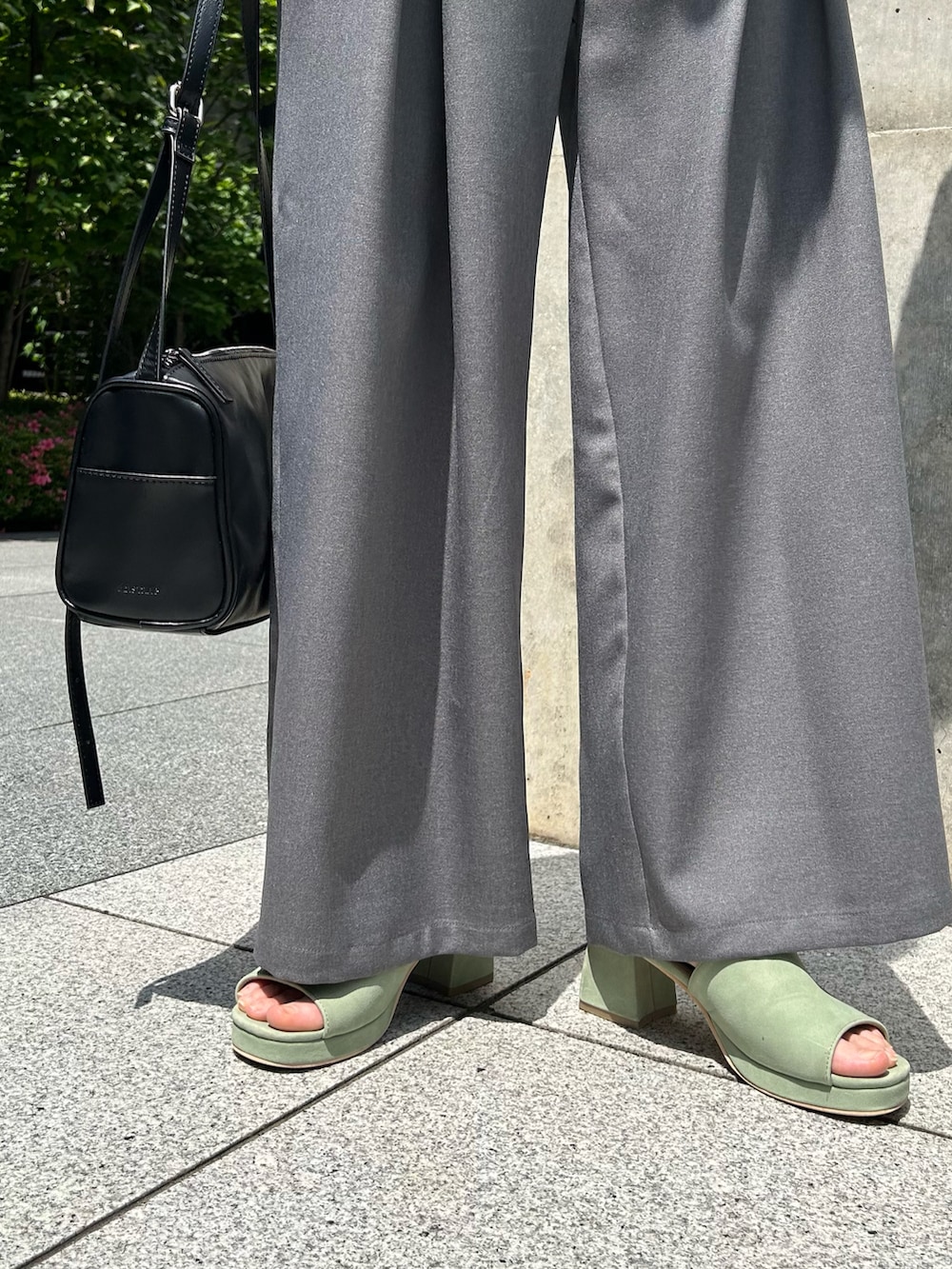 ホワイト系のTシャツ/カットソー、グレー系のスラックス、グリーン系のサンダルを着用したレディースの春コーディネートの4枚目の写真