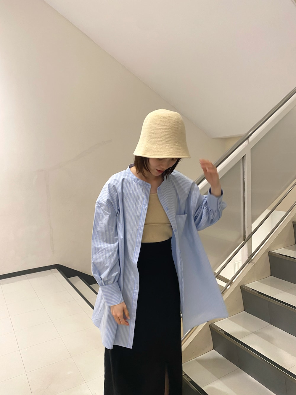 ブルー系のシャツ/ブラウス、ブラック系のスカート、ベージュ系のハットを着用したレディースの春コーディネートの2枚目の写真
