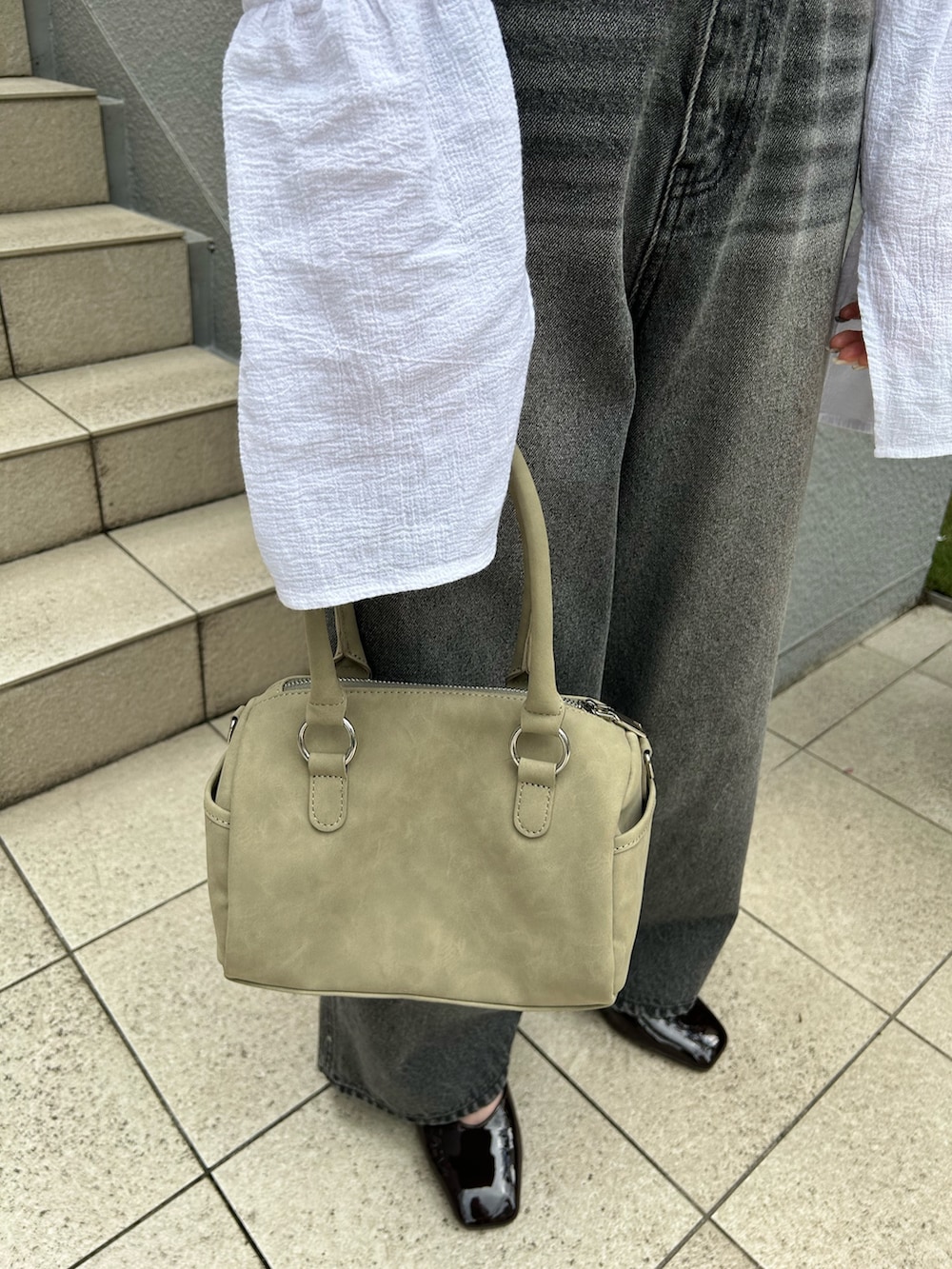 ホワイト系のカーディガン/ボレロ、ブラック系のデニムパンツ、グリーン系のボストンバッグを着用したレディースの夏コーディネートの4枚目の写真