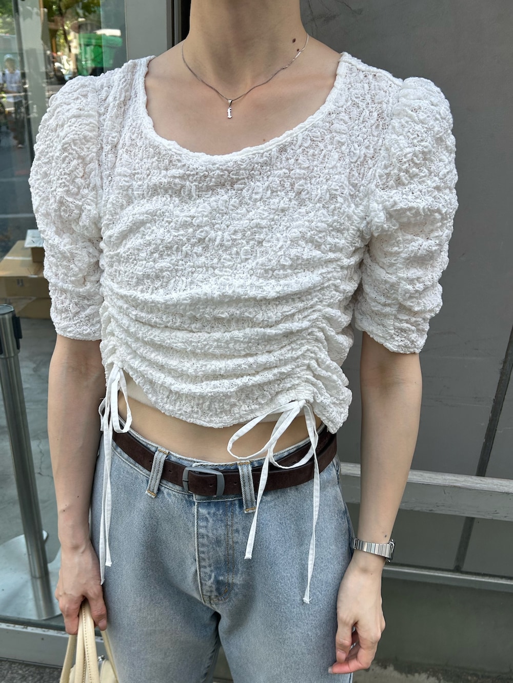 ホワイト系のTシャツ/カットソー、ホワイト系のサンダル、イエロー系のボストンバッグを着用したレディースの夏コーディネートの2枚目の写真