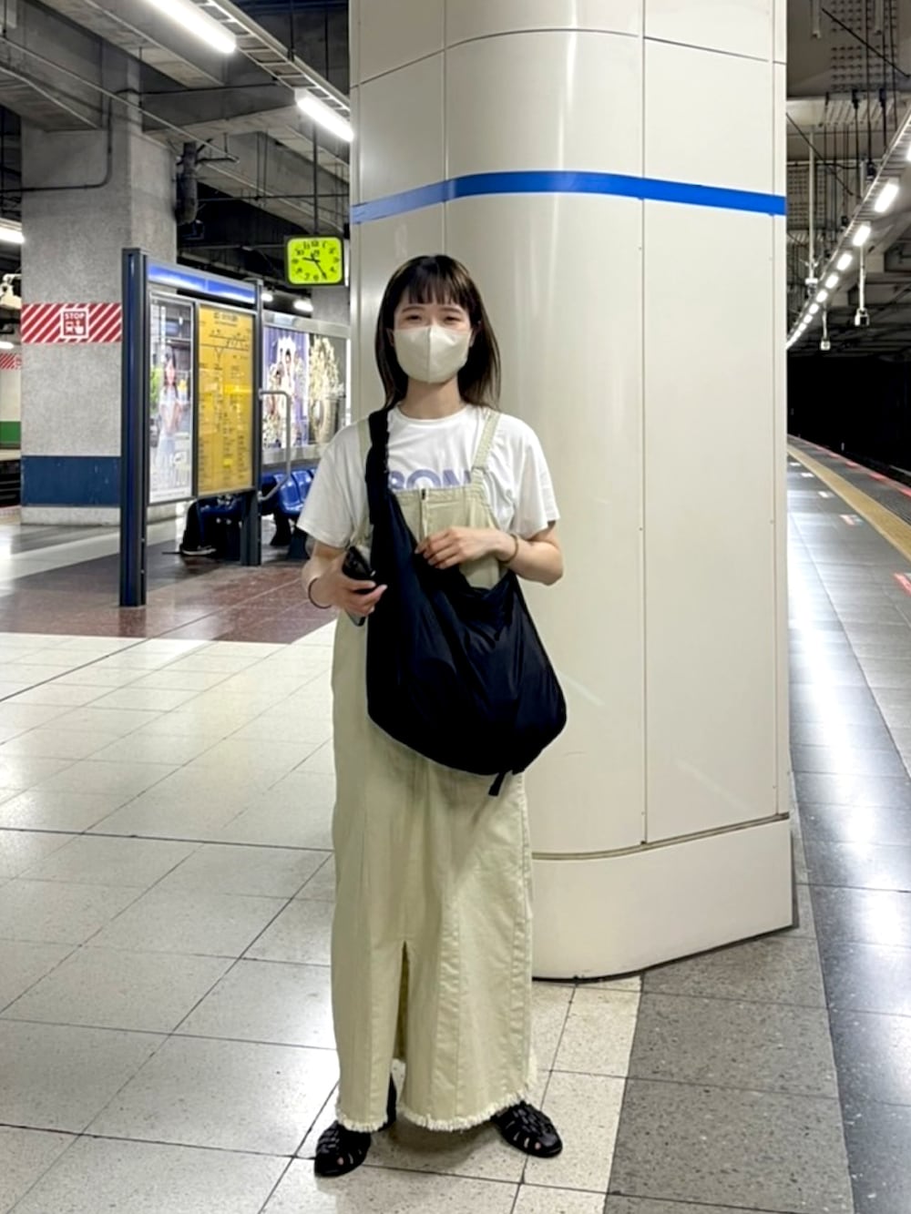 ベージュ系のジャンパースカートを着用したレディースの夏コーディネートの2枚目の写真