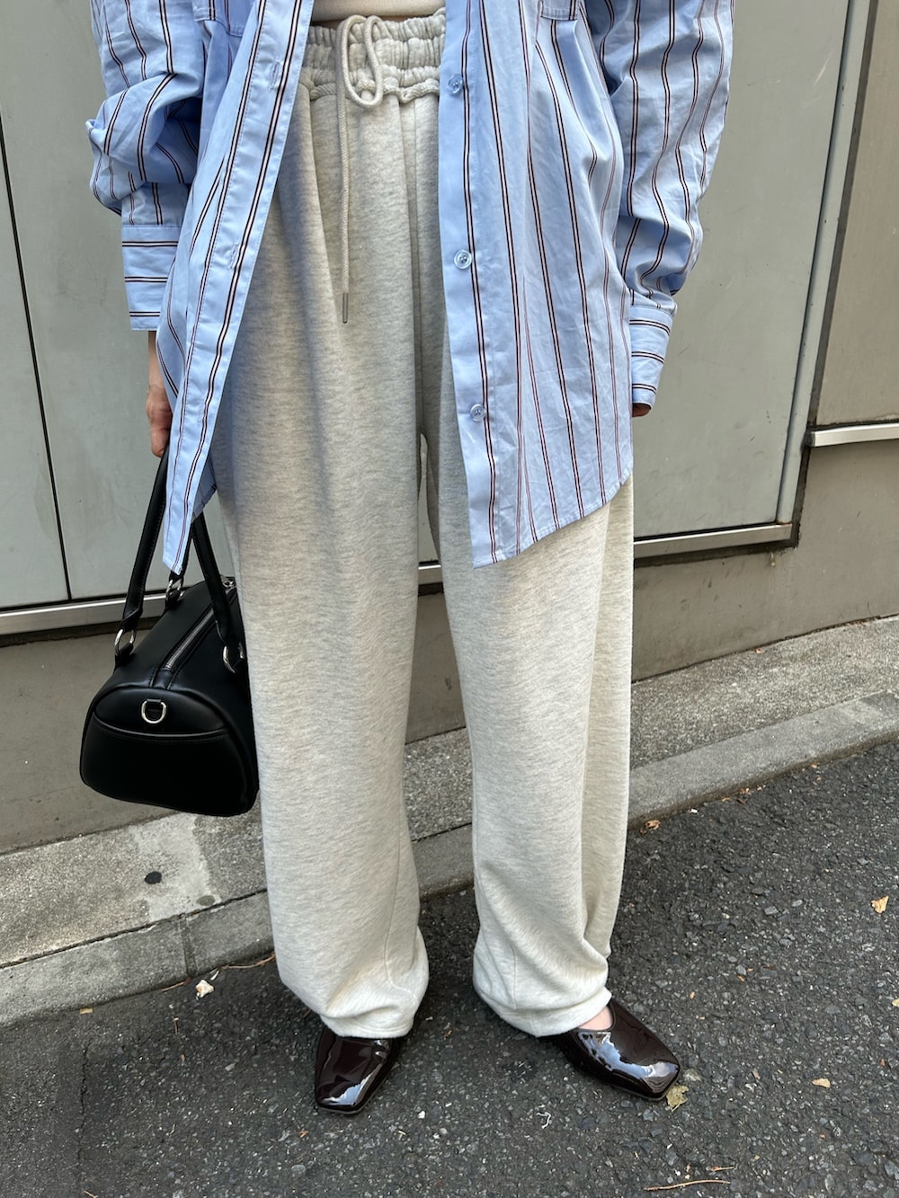 ブルー系のシャツ/ブラウス、ホワイト系のスウェットパンツ、ブラック系のボストンバッグを着用したレディースの夏コーディネートの5枚目の写真