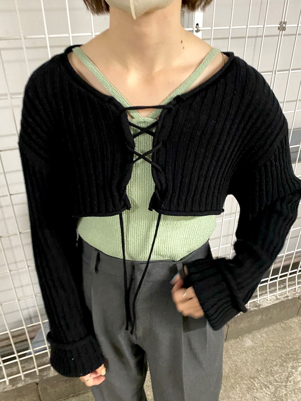ブラック系のシャツ/ブラウス、グリーン系のキャミソール、グレー系のスラックスを着用したレディースの春コーディネートの3枚目の写真