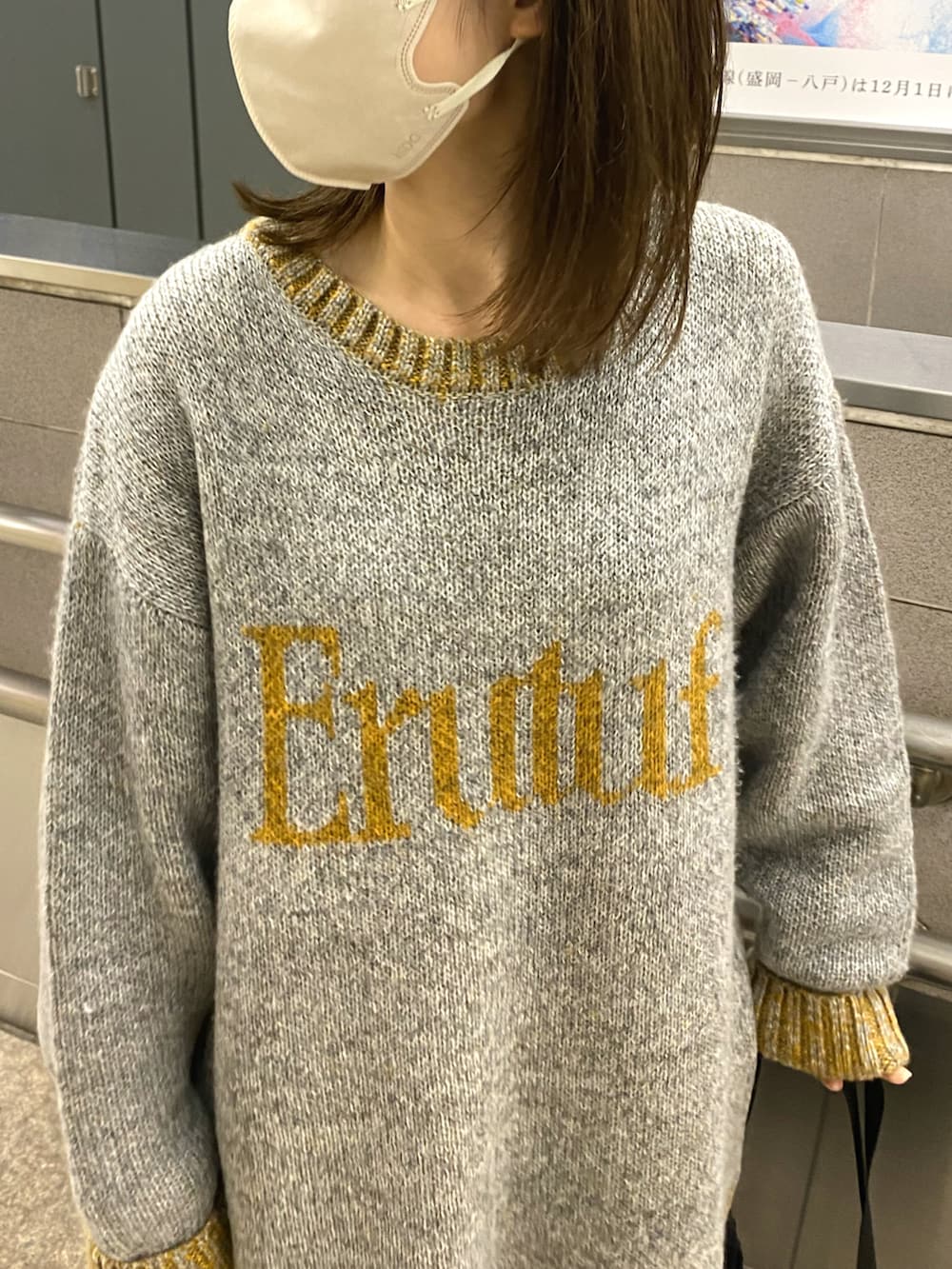 グレー系のニット/セーター、ブラック系のブーツを着用したレディースの秋コーディネートの2枚目の写真