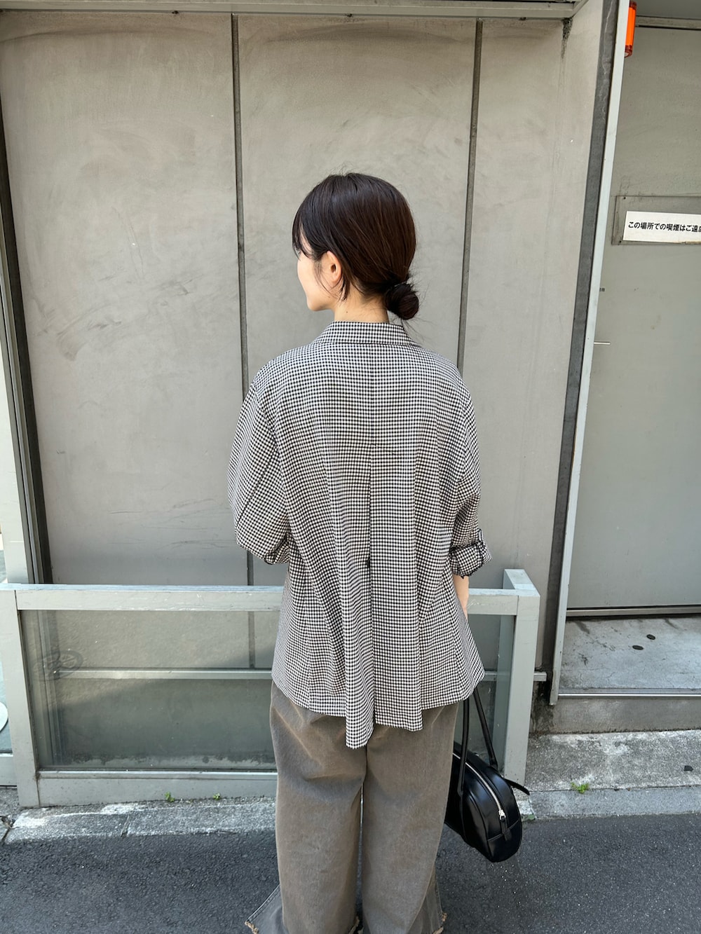 ブラック系のテーラードジャケット、グレー系のデニムパンツ、ブラック系のサンダルを着用したレディースの夏コーディネートの2枚目の写真