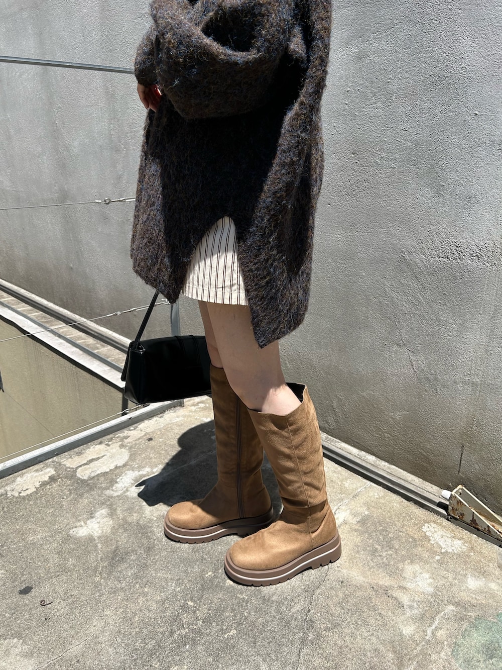 ブラウン系のニット/セーター、ブラック系のトートバッグ、ホワイト系のその他パンツを着用したレディースの夏コーディネートの5枚目の写真