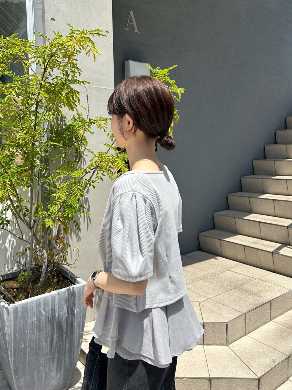 ブラック系のデニムパンツ、ホワイト系のサンダル、ブラック系のトートバッグを着用したレディースの春コーディネートの3枚目の写真