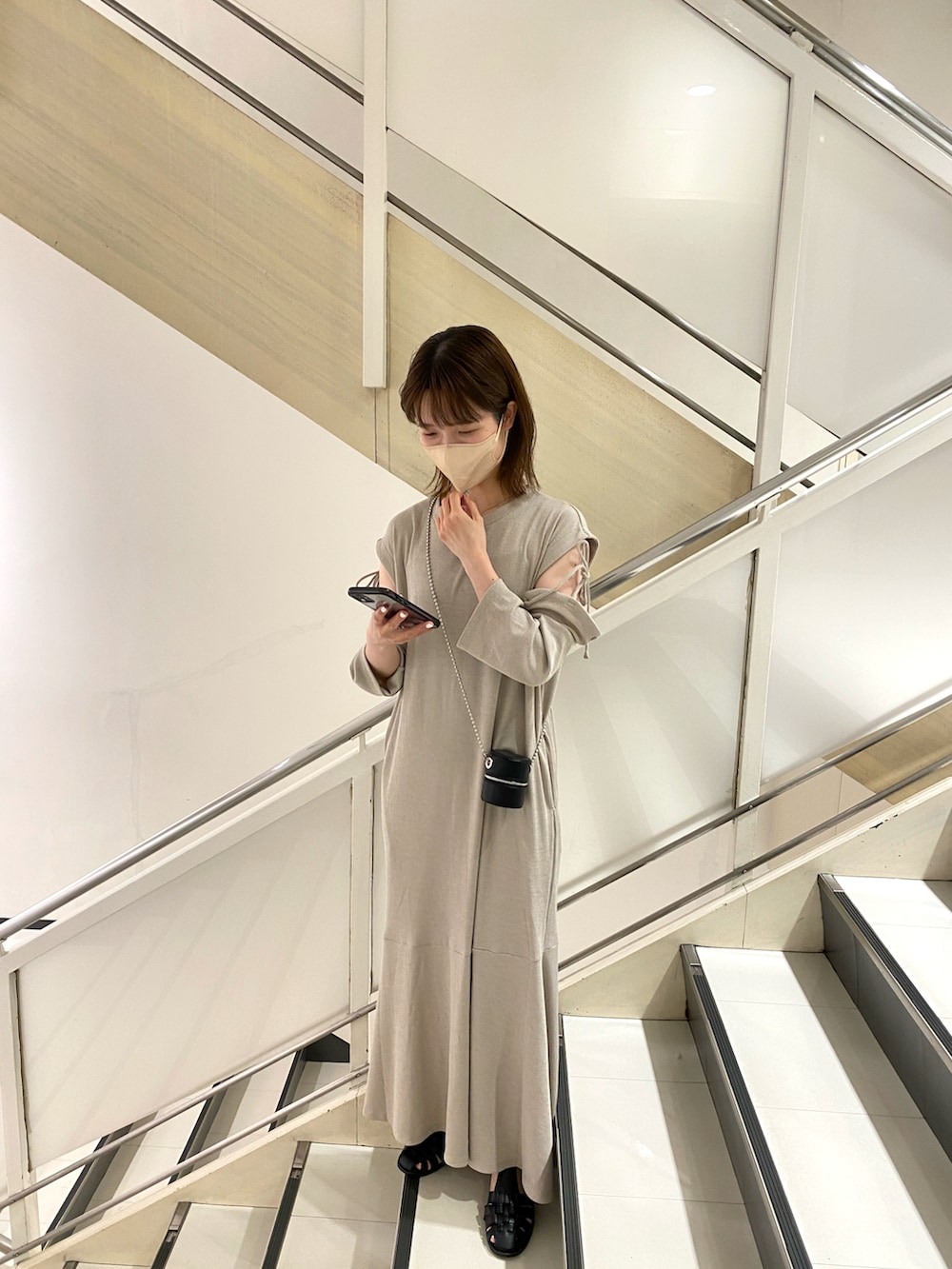 ホワイト系のショルダーバッグ、グレー系のワンピースを着用したレディースの夏コーディネートの2枚目の写真