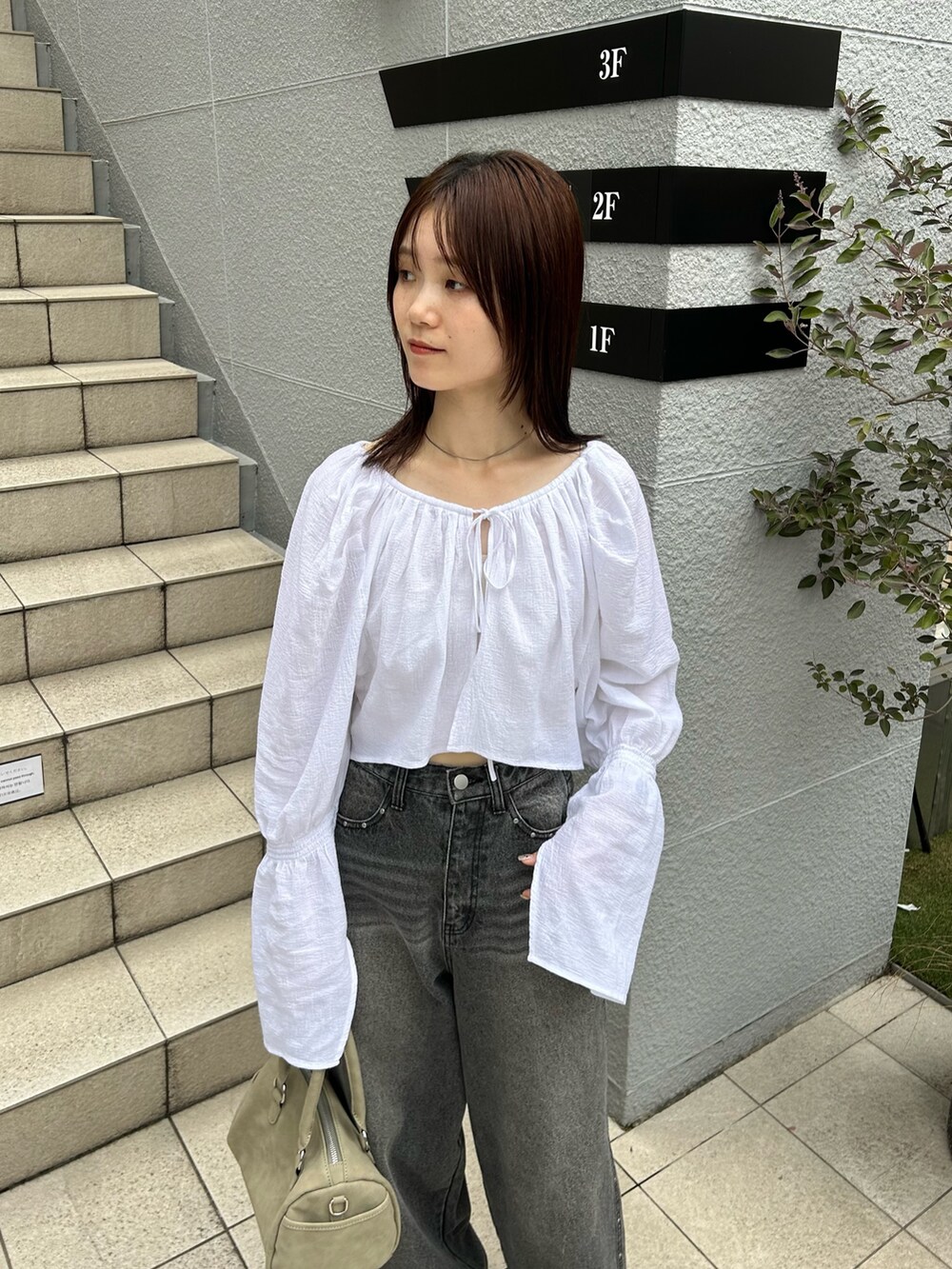 ホワイト系のカーディガン/ボレロ、ブラック系のデニムパンツ、グリーン系のボストンバッグを着用したレディースの夏コーディネートの2枚目の写真