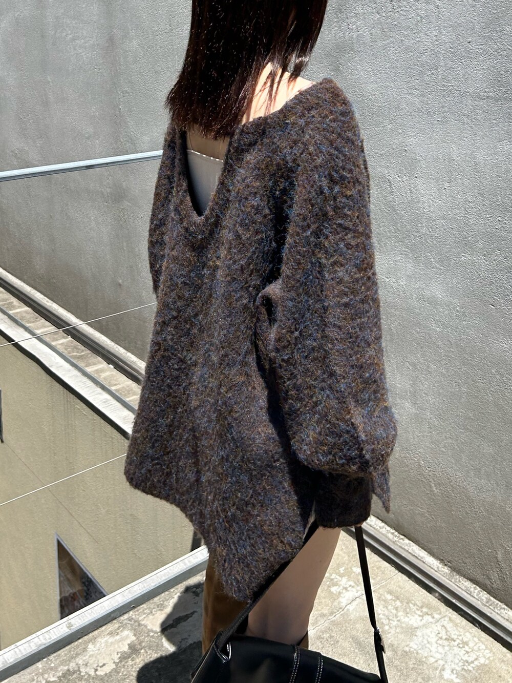 ブラウン系のニット/セーター、ブラック系のトートバッグ、ホワイト系のその他パンツを着用したレディースの夏コーディネートの3枚目の写真