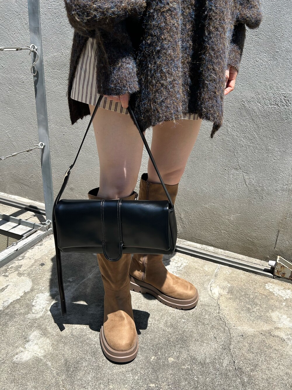 ブラウン系のニット/セーター、ブラック系のトートバッグ、ホワイト系のその他パンツを着用したレディースの夏コーディネートの6枚目の写真