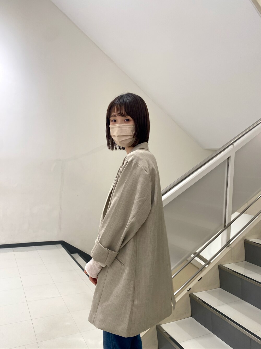 グレー系のテーラードジャケット、ホワイト系のTシャツ/カットソー、ブルー系のデニムパンツを着用したレディースの冬コーディネートの2枚目の写真