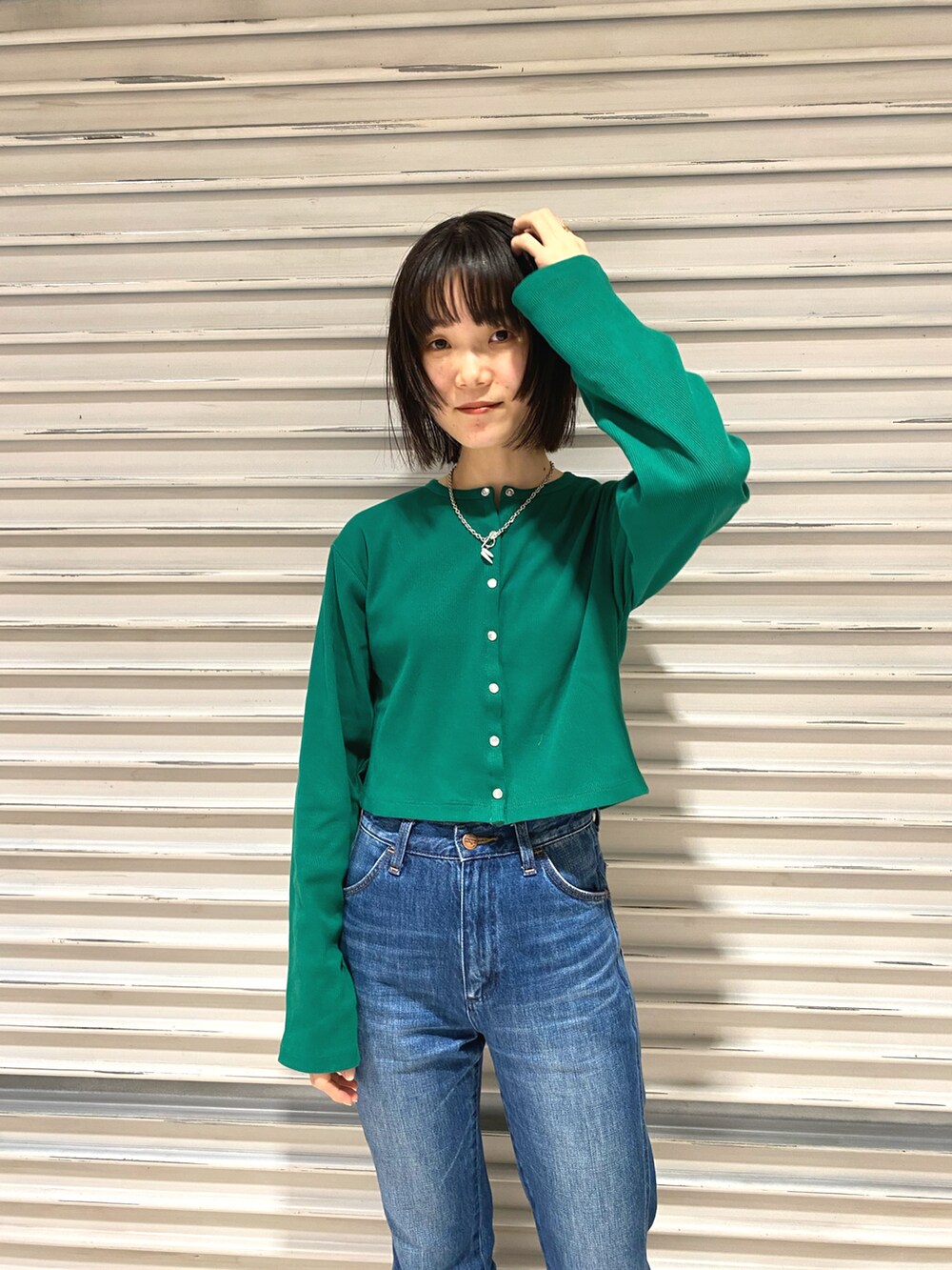 グリーン系のカーディガン/ボレロ、ブルー系のデニムパンツ、ブラック系のサンダルを着用したレディースの冬コーディネートの2枚目の写真