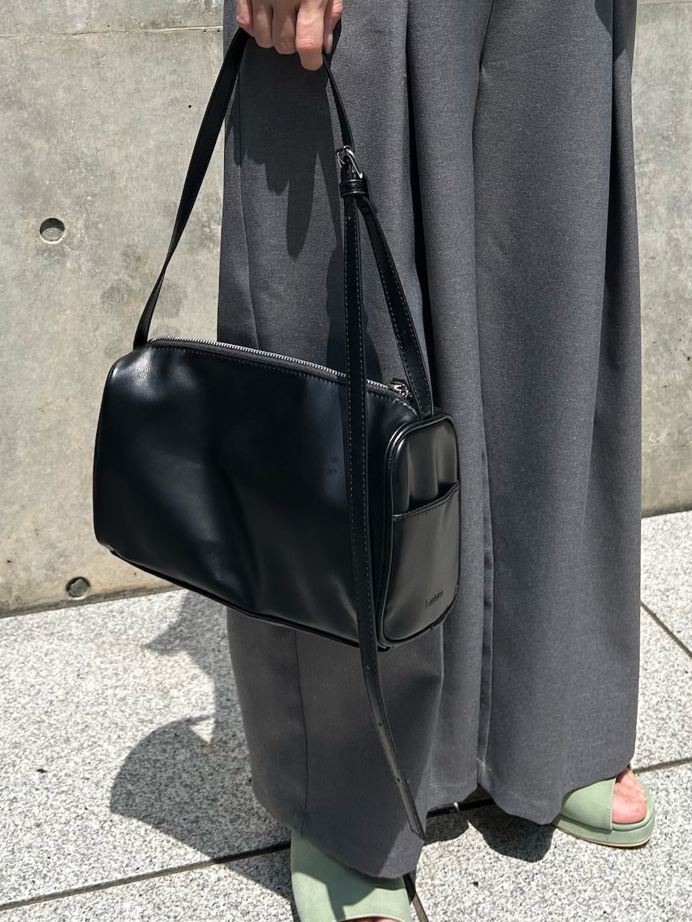 ホワイト系のTシャツ/カットソー、グレー系のスラックス、グリーン系のサンダルを着用したレディースの春コーディネートの5枚目の写真