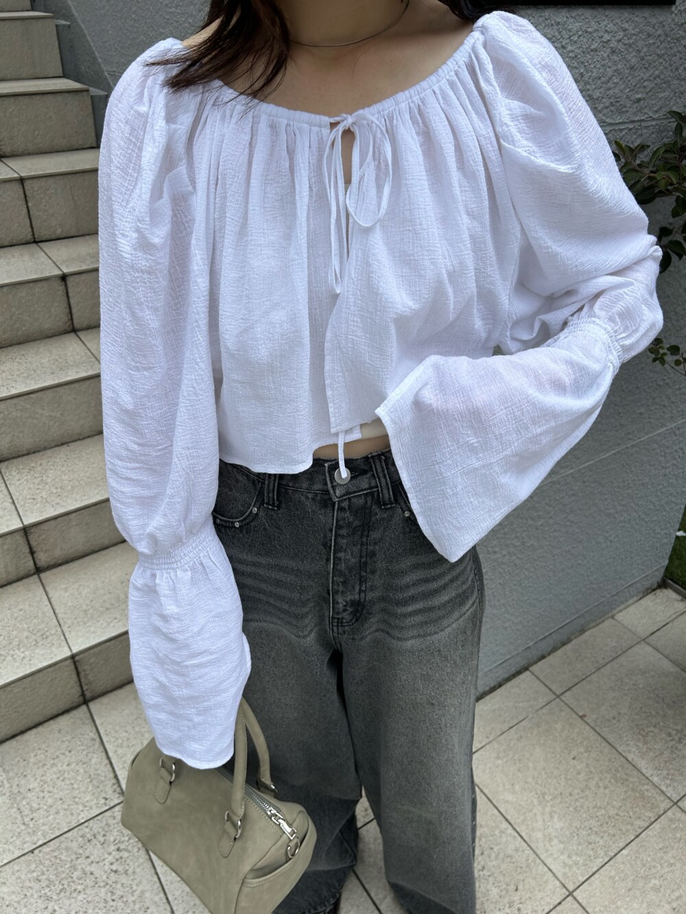 ホワイト系のカーディガン/ボレロ、ブラック系のデニムパンツ、グリーン系のボストンバッグを着用したレディースの夏コーディネートの3枚目の写真