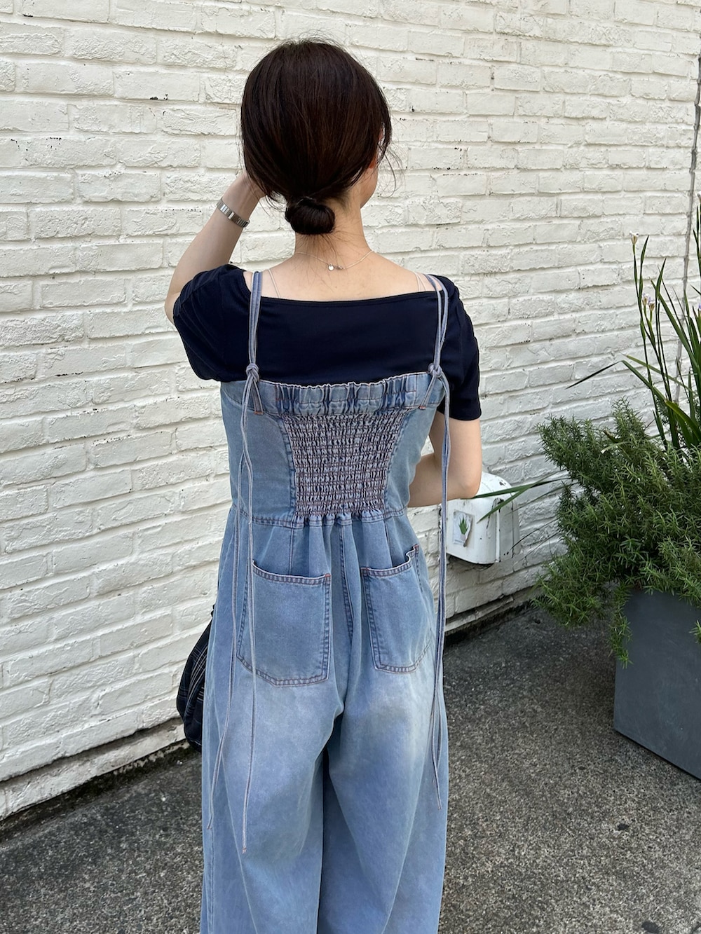 ブラック系のトートバッグ、ブルー系のサロペット/オーバーオール、ブラック系のサンダルを着用したレディースの春コーディネートの3枚目の写真