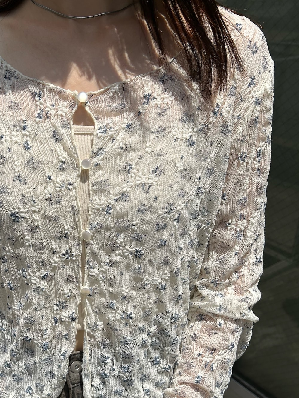 ホワイト系のカーディガン/ボレロ、グレー系のデニムパンツ、ブラック系のショルダーバッグを着用したレディースの夏コーディネートの3枚目の写真