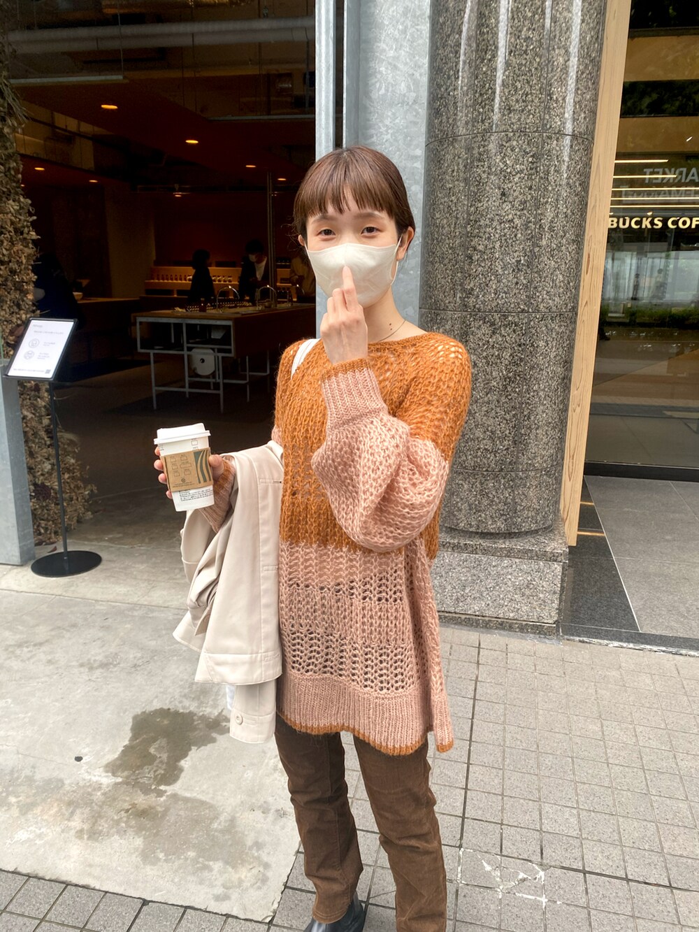 ブラウン系のニット/セーターを着用したレディースの秋コーディネートの2枚目の写真