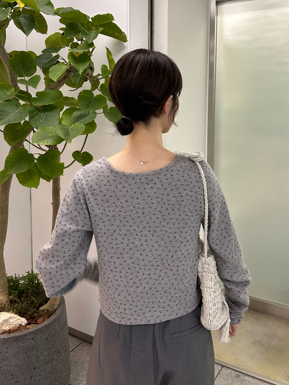 グレー系のカーディガン/ボレロ、グレー系のスラックス、ブラック系のサンダルを着用したレディースの春コーディネートの4枚目の写真