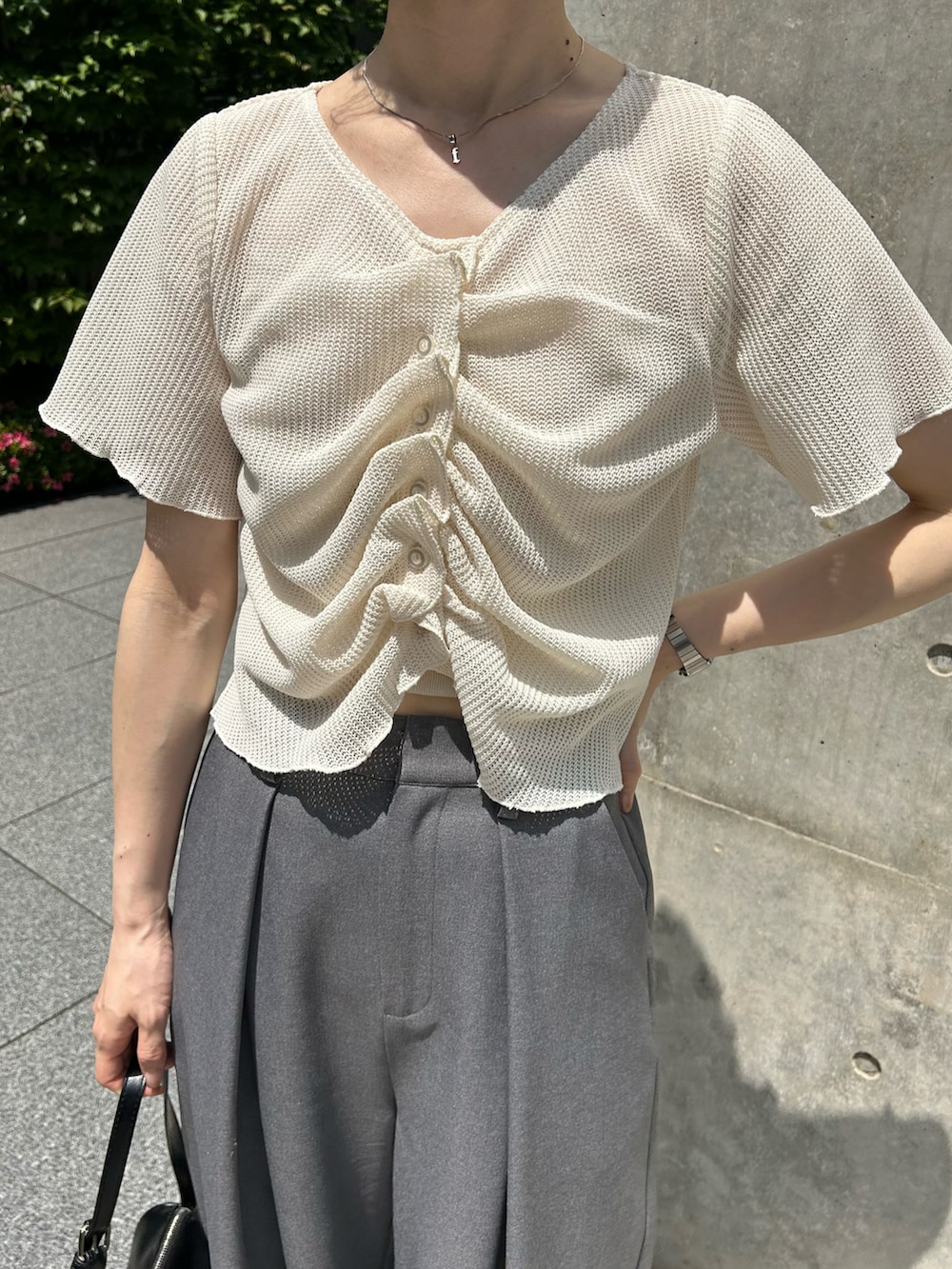 ホワイト系のTシャツ/カットソー、グレー系のスラックス、グリーン系のサンダルを着用したレディースの春コーディネートの2枚目の写真