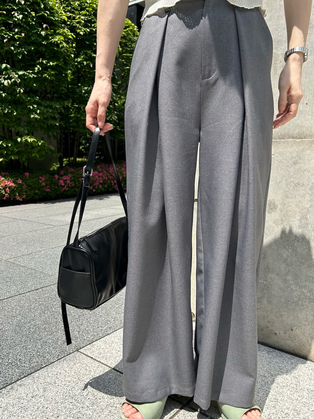 ホワイト系のTシャツ/カットソー、グレー系のスラックス、グリーン系のサンダルを着用したレディースの春コーディネートの3枚目の写真