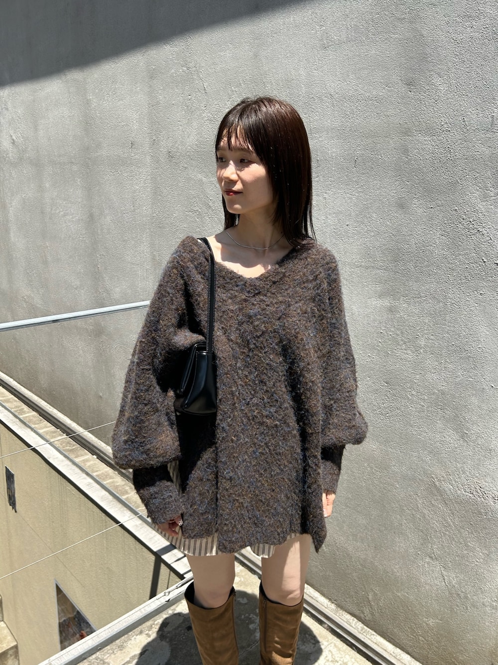ブラウン系のニット/セーター、ブラック系のトートバッグ、ホワイト系のその他パンツを着用したレディースの夏コーディネートの2枚目の写真