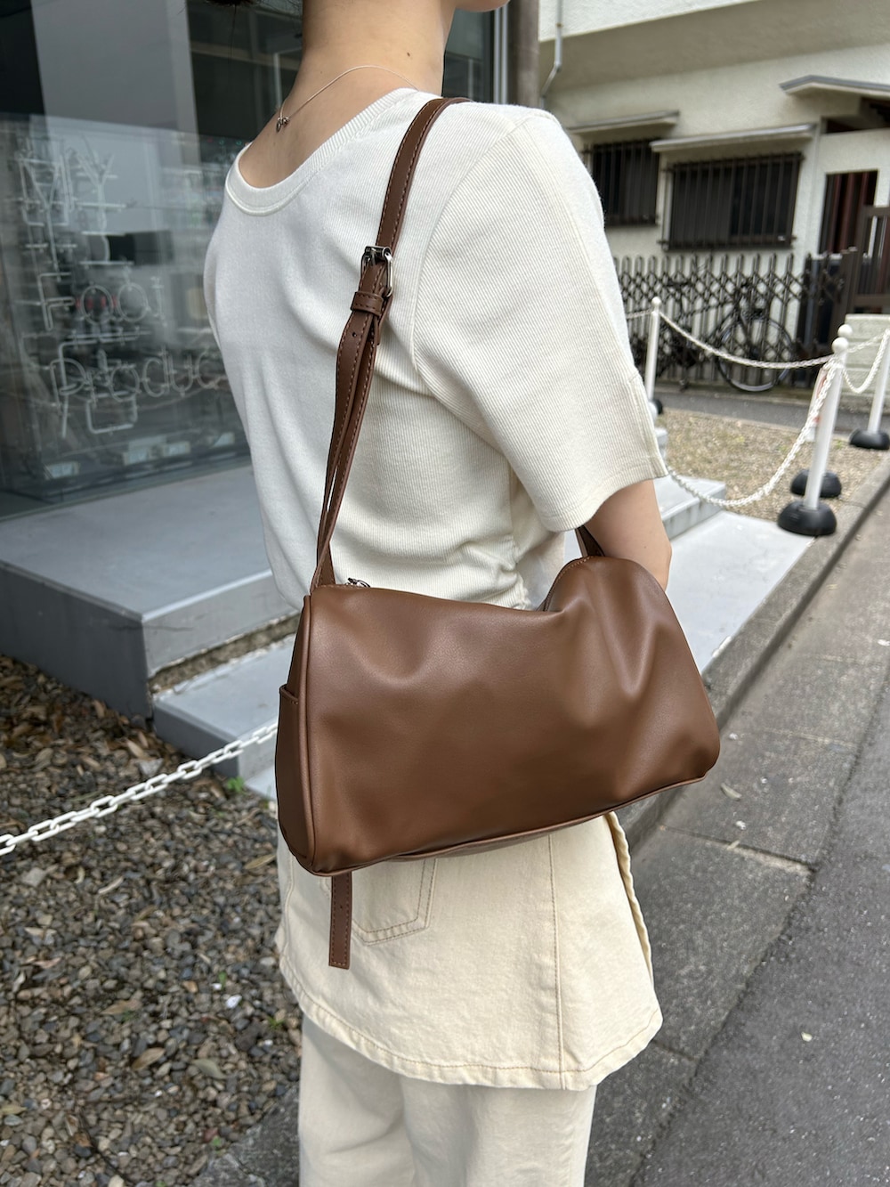 ホワイト系のTシャツ/カットソー、ベージュ系のデニムパンツ、ブラウン系のショルダーバッグを着用したレディースの夏コーディネートの4枚目の写真