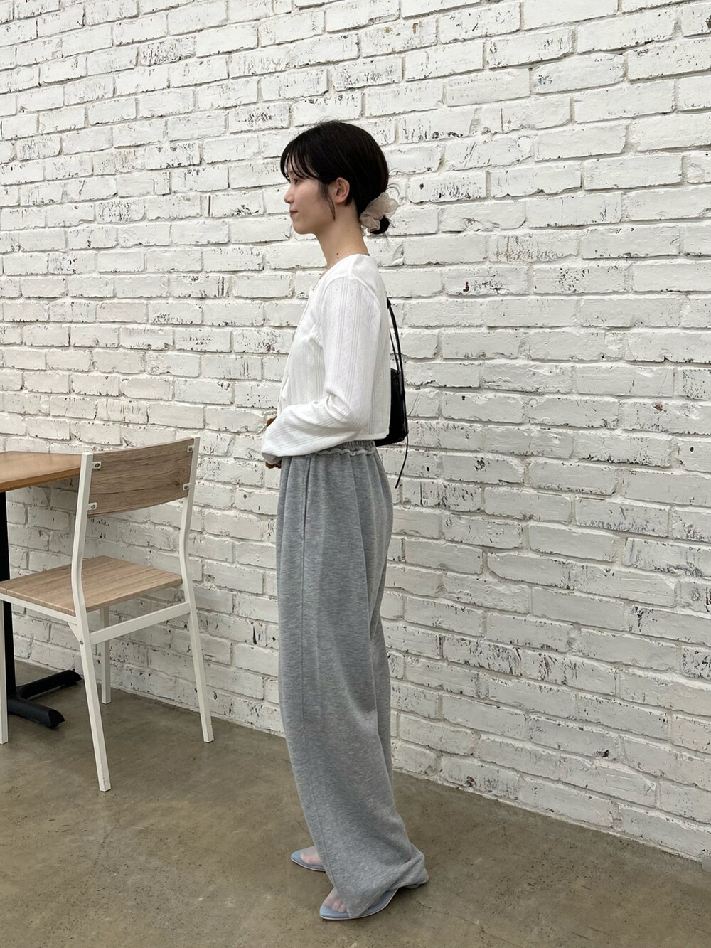 ホワイト系のカーディガン/ボレロ、ブラック系のショルダーバッグ、ブルー系のサンダルを着用したレディースの春コーディネートの2枚目の写真
