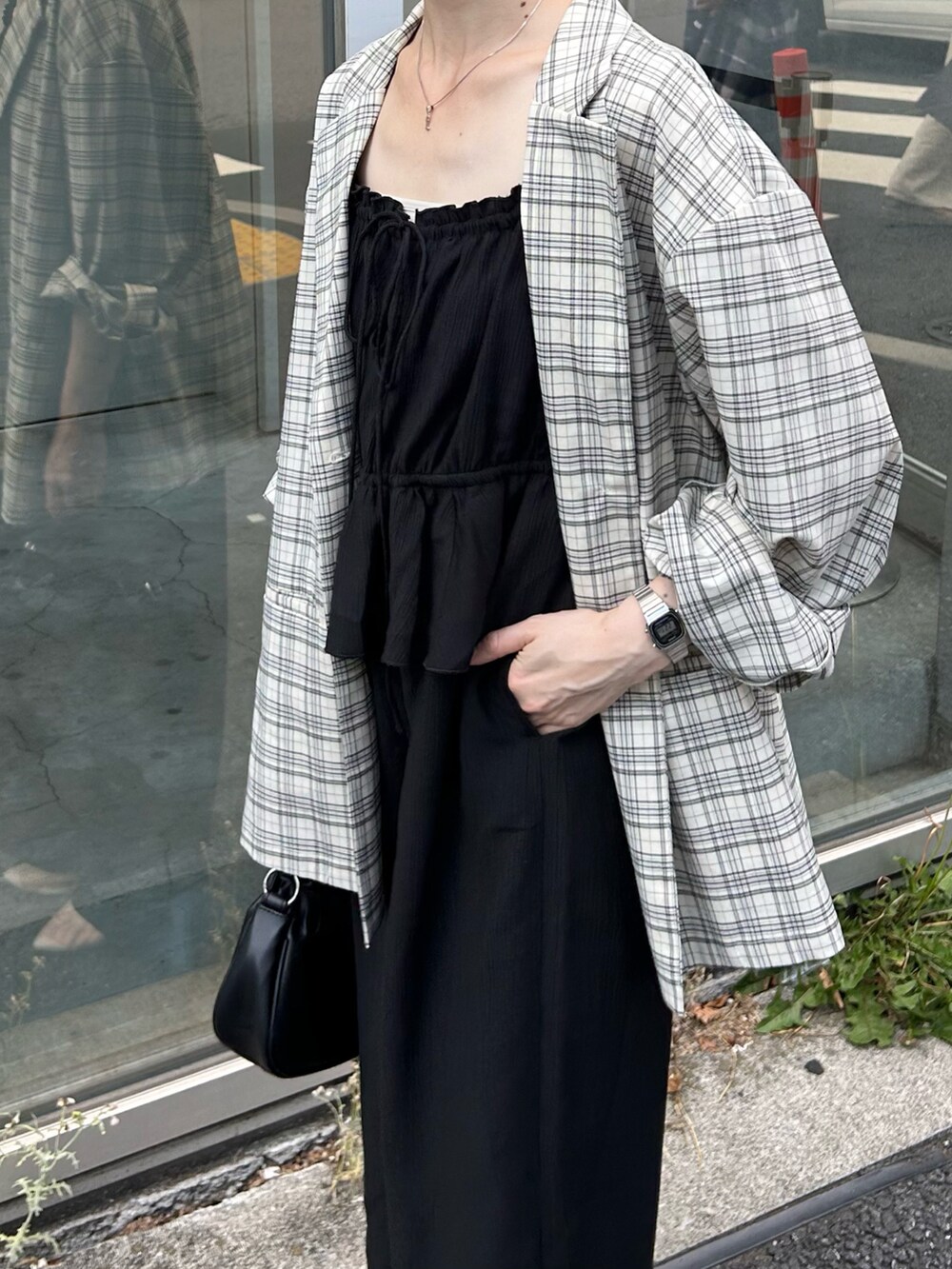 ブラック系のショルダーバッグ、ブラック系のサロペット/オーバーオール、ホワイト系のテーラードジャケットを着用したレディースの夏コーディネートの3枚目の写真