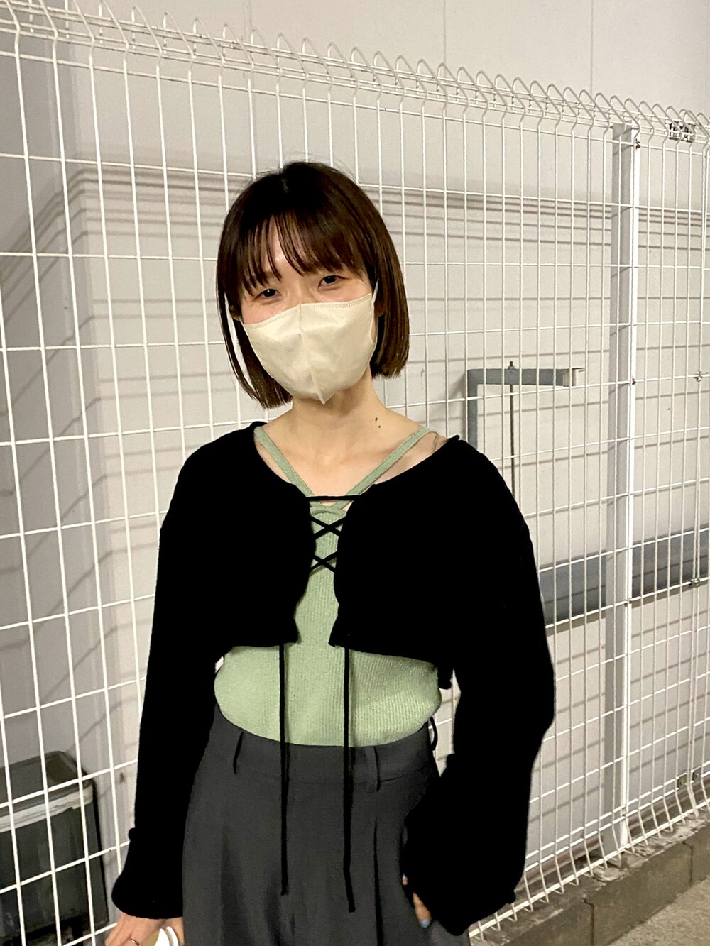 ブラック系のシャツ/ブラウス、グリーン系のキャミソール、グレー系のスラックスを着用したレディースの春コーディネートの2枚目の写真