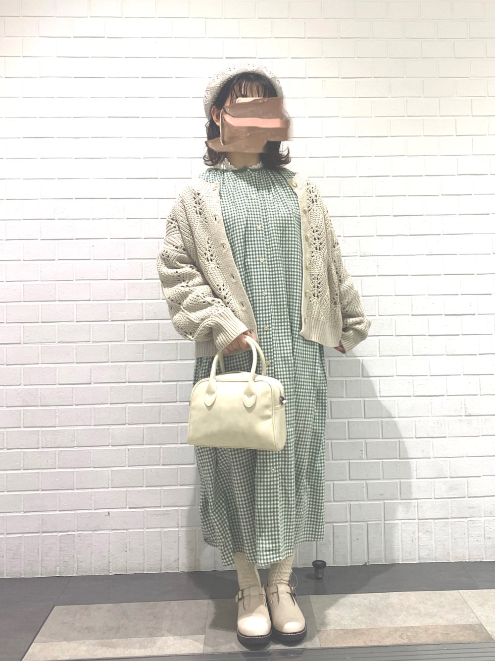 ホワイト系のショルダーバッグ、グリーン系のワンピース、ホワイト系のその他シューズを着用したレディースの冬コーディネートの2枚目の写真