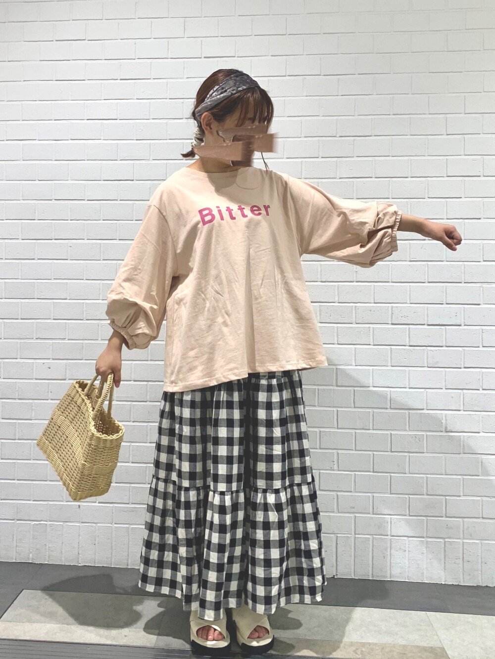 ベージュ系のトートバッグ、ピンク系のTシャツ/カットソー、ホワイト系のスカートを着用したレディースの夏コーディネートの2枚目の写真