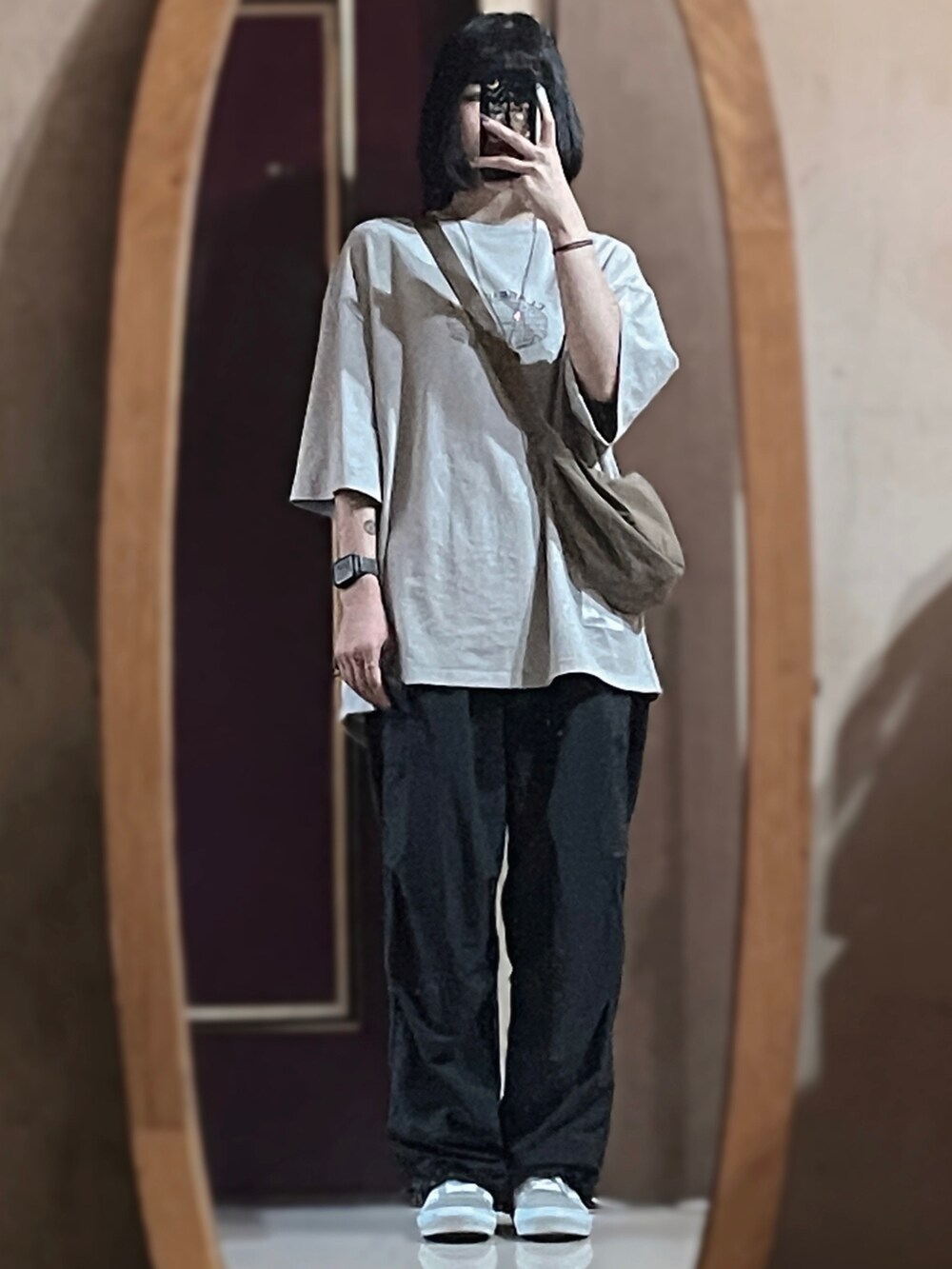 シルバー系のシューズ、ブラック系のパンツ、ベージュ系のバッグを着用したレディースの夏コーディネートの2枚目の写真