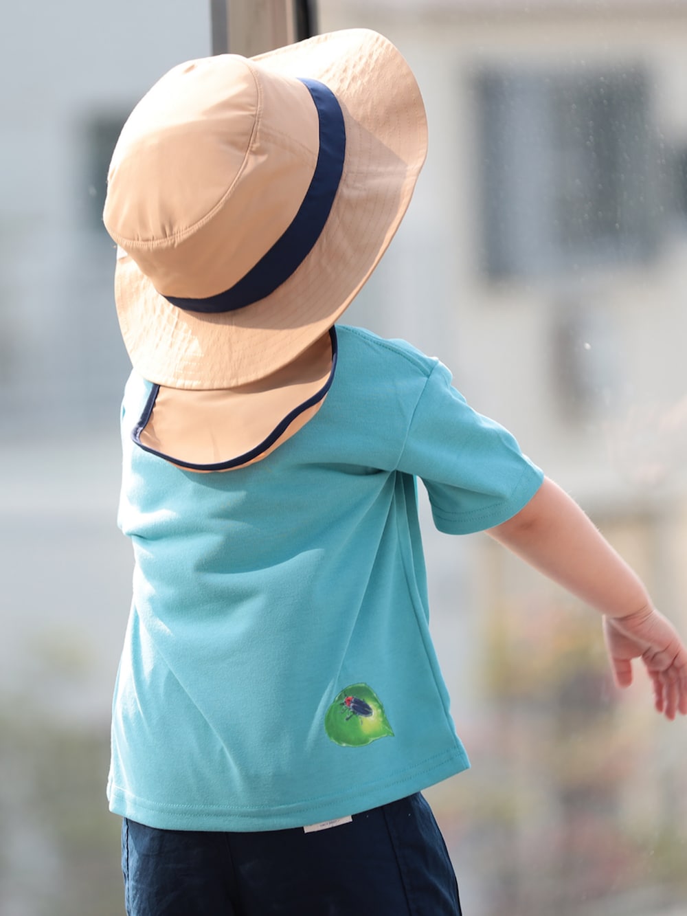 ブルー系のその他パンツ、ブルー系のTシャツ/カットソー、ベージュ系のハットを着用したキッズの春コーディネートの3枚目の写真