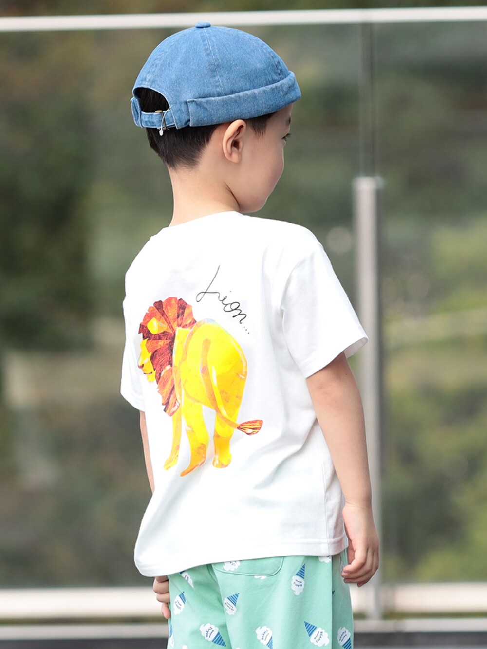 グリーン系のその他パンツ、ホワイト系のTシャツ/カットソー、ブルー系のキャップを着用したキッズの夏コーディネートの2枚目の写真