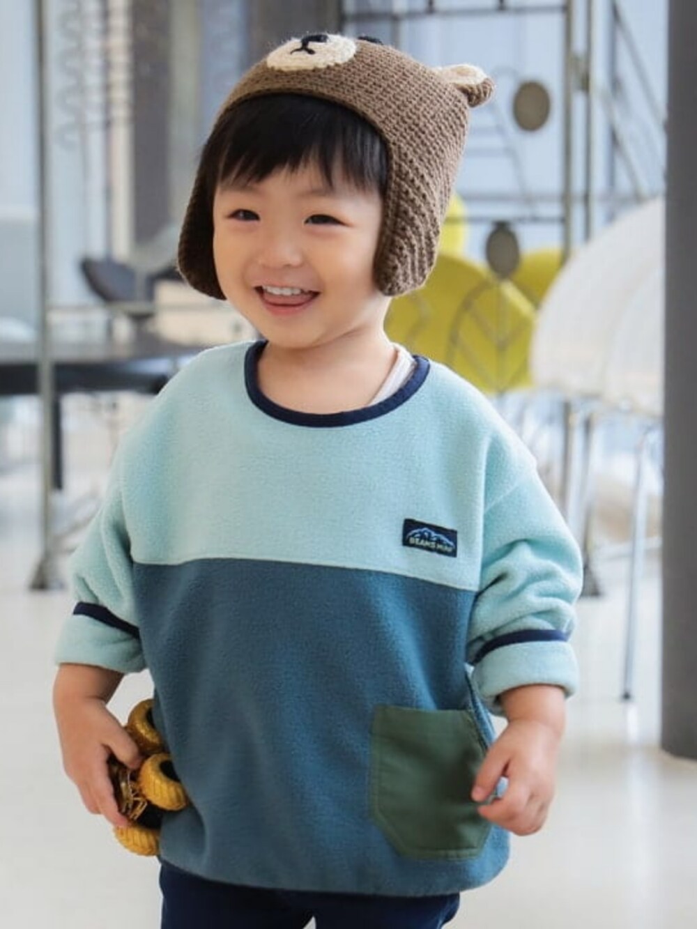 ブルー系のその他パンツ、グリーン系のスウェット、ブラウン系のニットキャップ/ビーニーを着用したキッズの冬コーディネートの3枚目の写真